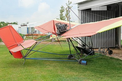 View of beautiful ultralight airplane near hangar in field