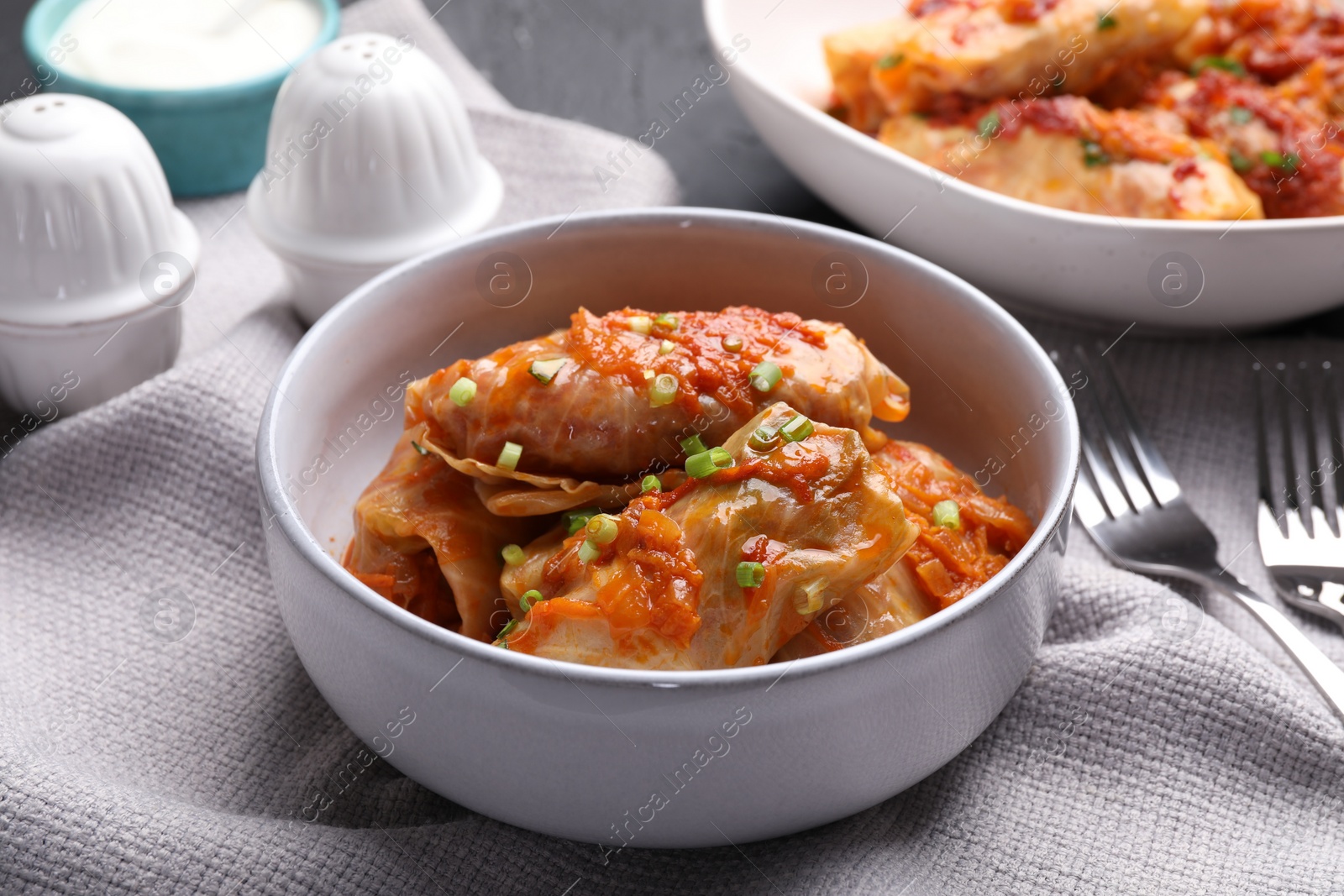 Photo of Delicious stuffed cabbage rolls cooked with homemade tomato sauce on table, closeup