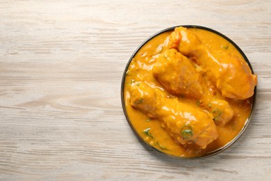 Tasty chicken curry on wooden table, top view. Space for text