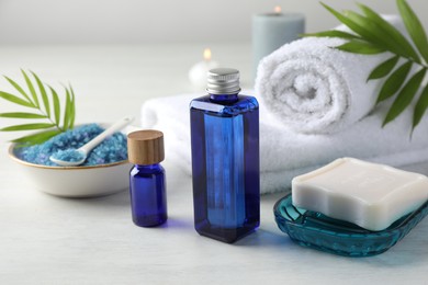 Spa composition. Cosmetic products, soap, towels, sea salt and burning candles on light table