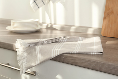 Photo of Light grey cotton towel on wooden table in kitchen