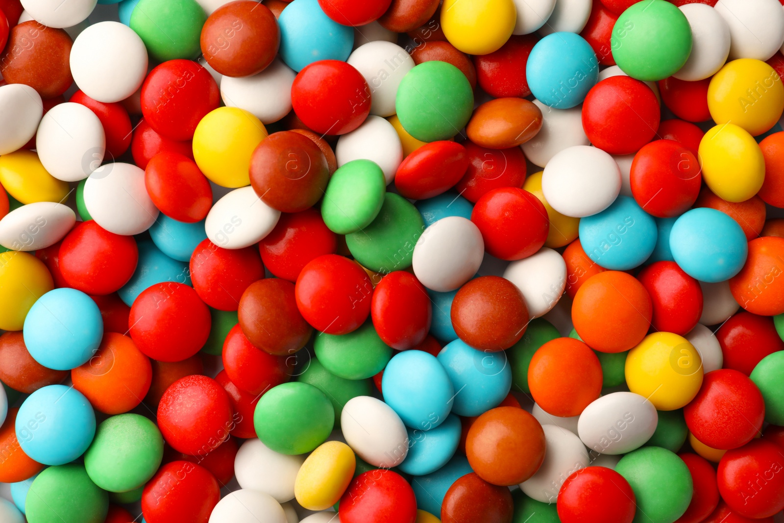 Photo of Many small colorful candies as background, top view