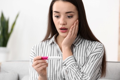 Young woman with pregnancy test at home. Gynecology and childbirth