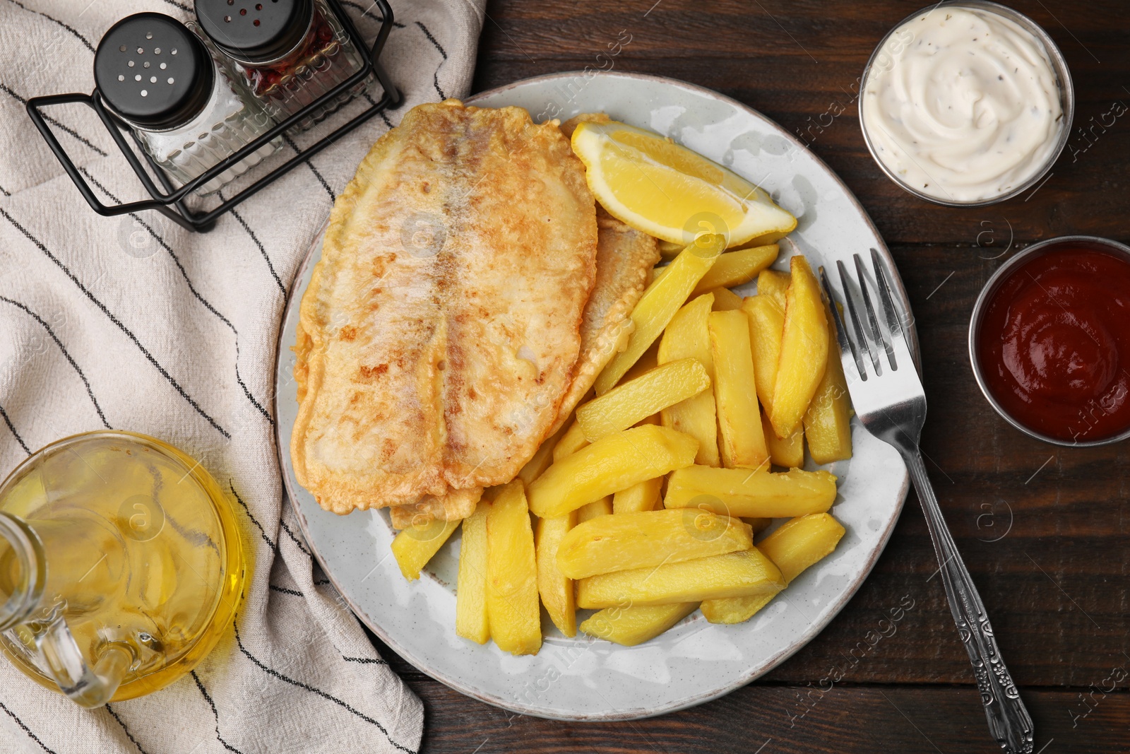Photo of Delicious fish and chips served on wooden table, flat lay