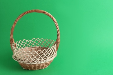 Empty wicker basket on green background, space for text. Easter item