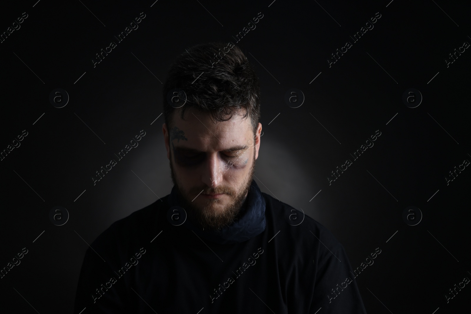 Photo of Man with bruise on dark background. Hostage