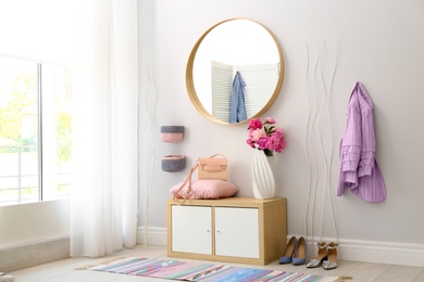 Photo of Stylish hallway interior with round mirror on white wall