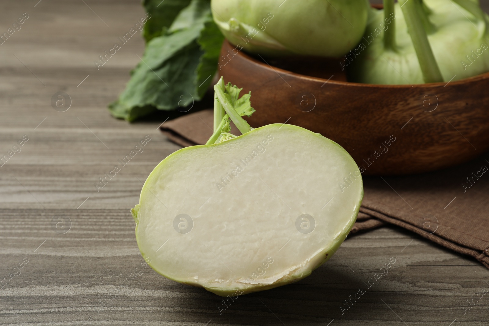 Photo of Whole and cut kohlrabi plants on wooden table