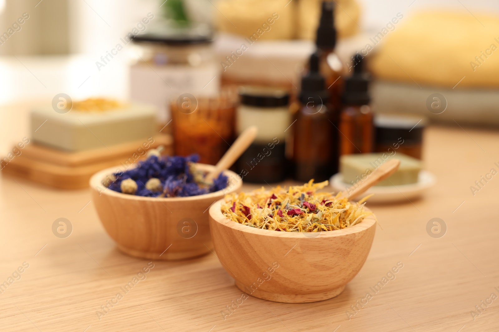 Photo of Dry flowers on wooden table indoors. Spa time