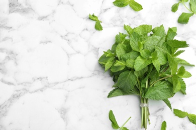 Bunch of fresh mint on white marble  background, top view. Space for text