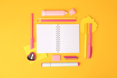 Flat lay composition with open notebook and different school stationery on yellow background, space for text. Back to school