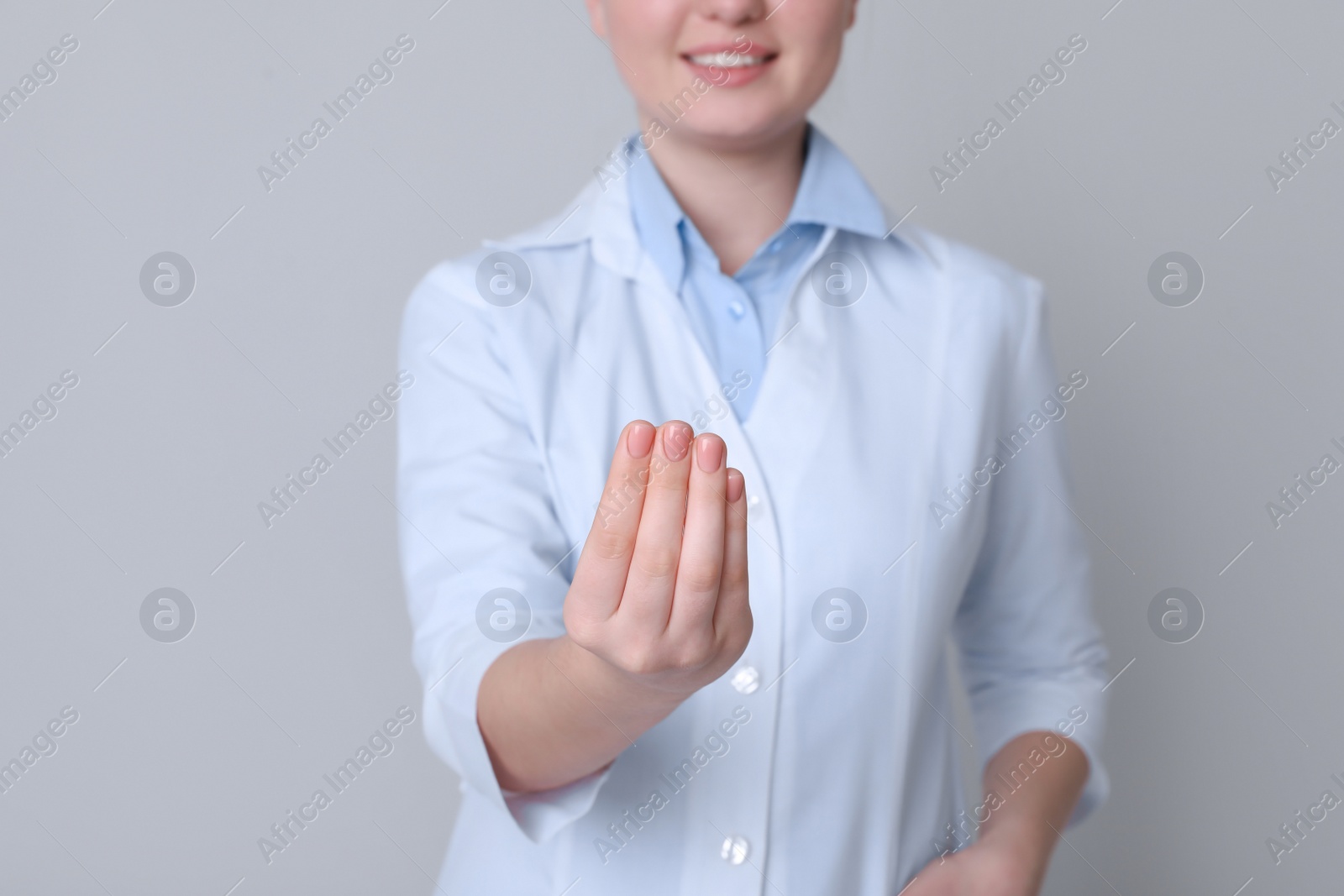 Photo of Dental assistant holding something on light grey background, closeup