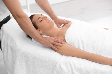 Photo of Relaxed woman receiving shoulders massage in wellness center