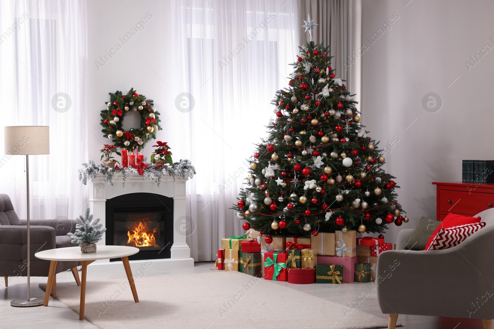 Photo of Beautiful Christmas tree and gifts near fireplace in festively decorated living room