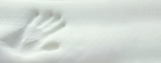 Handprint on white memory foam pillow, closeup. Banner design with space for text