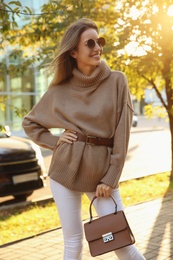 Beautiful young woman wearing stylish sweater in autumn park