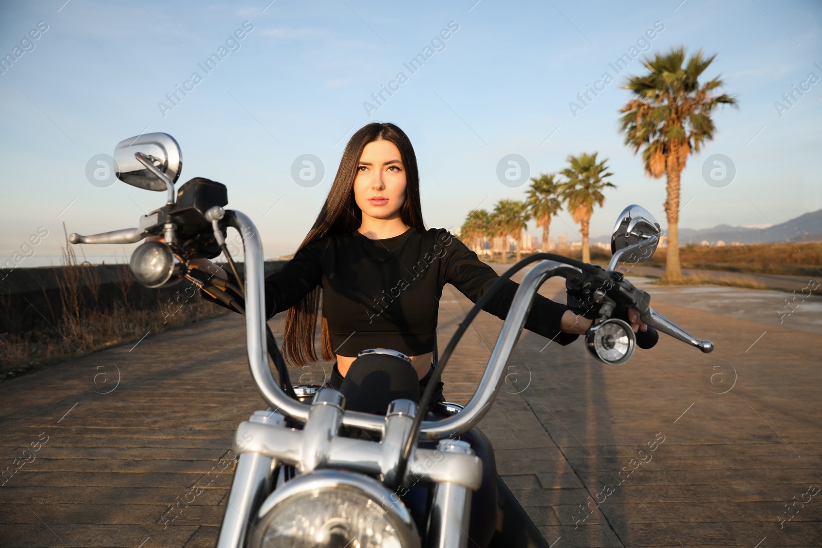 Photo of Beautiful young woman riding motorcycle on sunny day