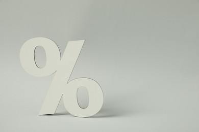 Photo of White percent sign on light grey background. Space for text