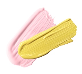 Image of Strokes of pink and yellow color correcting concealers on white background, top view