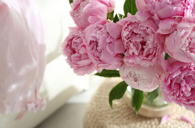 Photo of Bouquet of beautiful peonies on pouf indoors, closeup