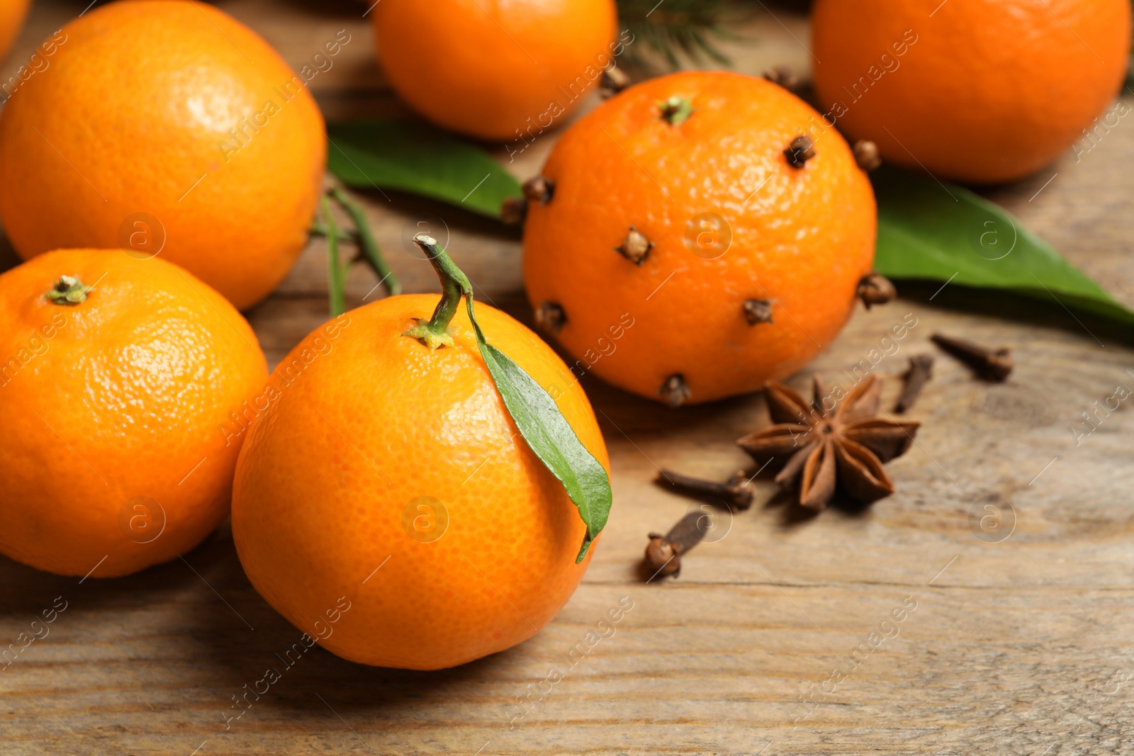 Photo of Fresh tangerines on wooden table, closeup. Christmas atmosphere