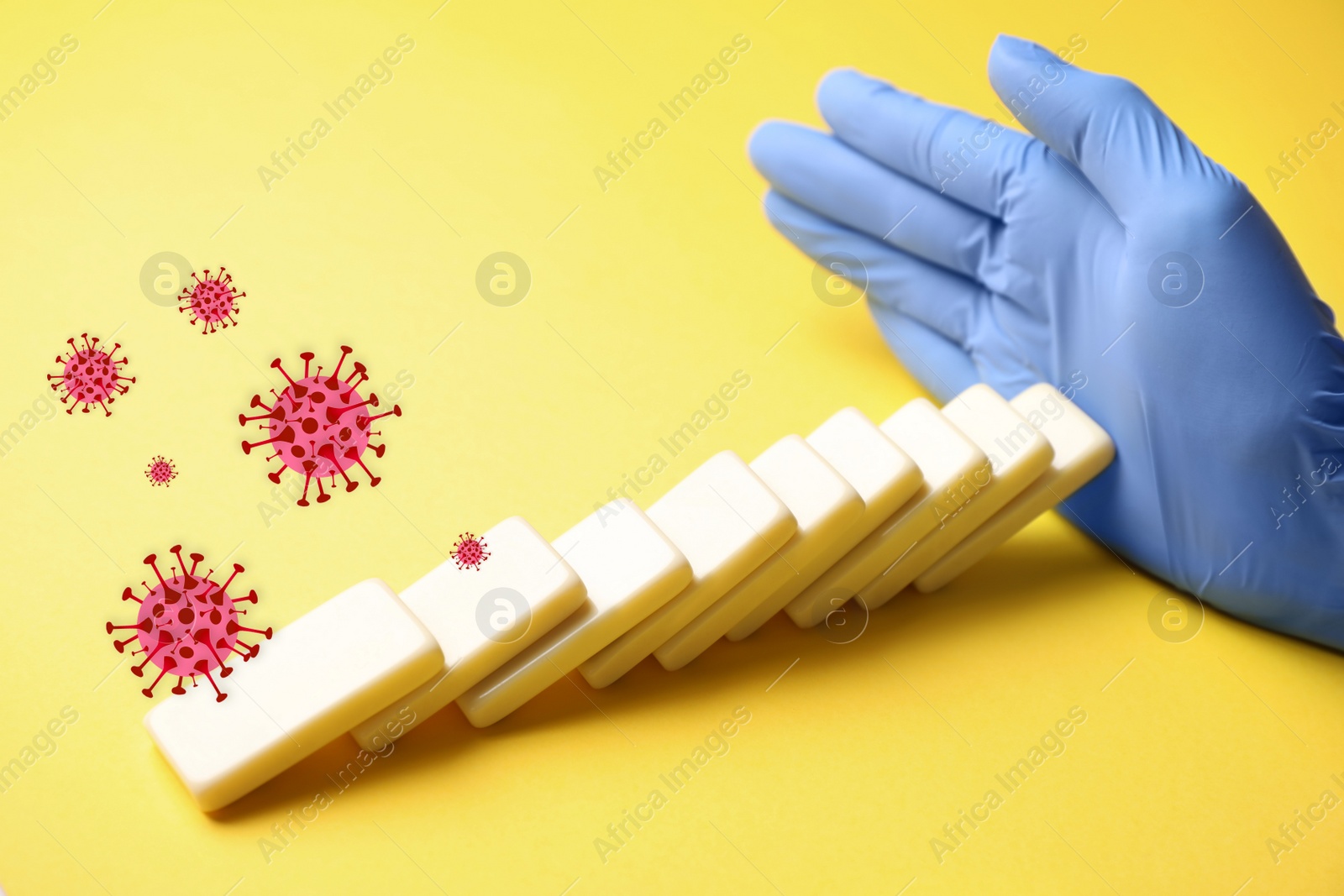 Image of Doctor stopping domino effect on yellow background, closeup. Prevent spreading of coronavirus