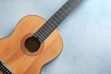 Beautiful classical guitar on color background, top view