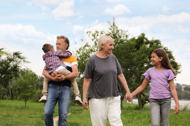 Cute children with grandparents walking in park