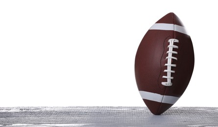 Photo of American football ball on grey wooden table against white background. Space for text