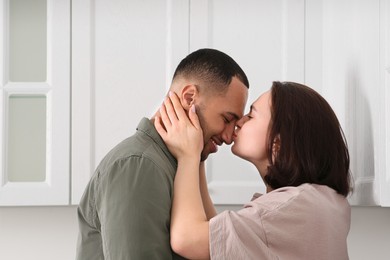 Dating agency. Woman kissing her boyfriend indoors