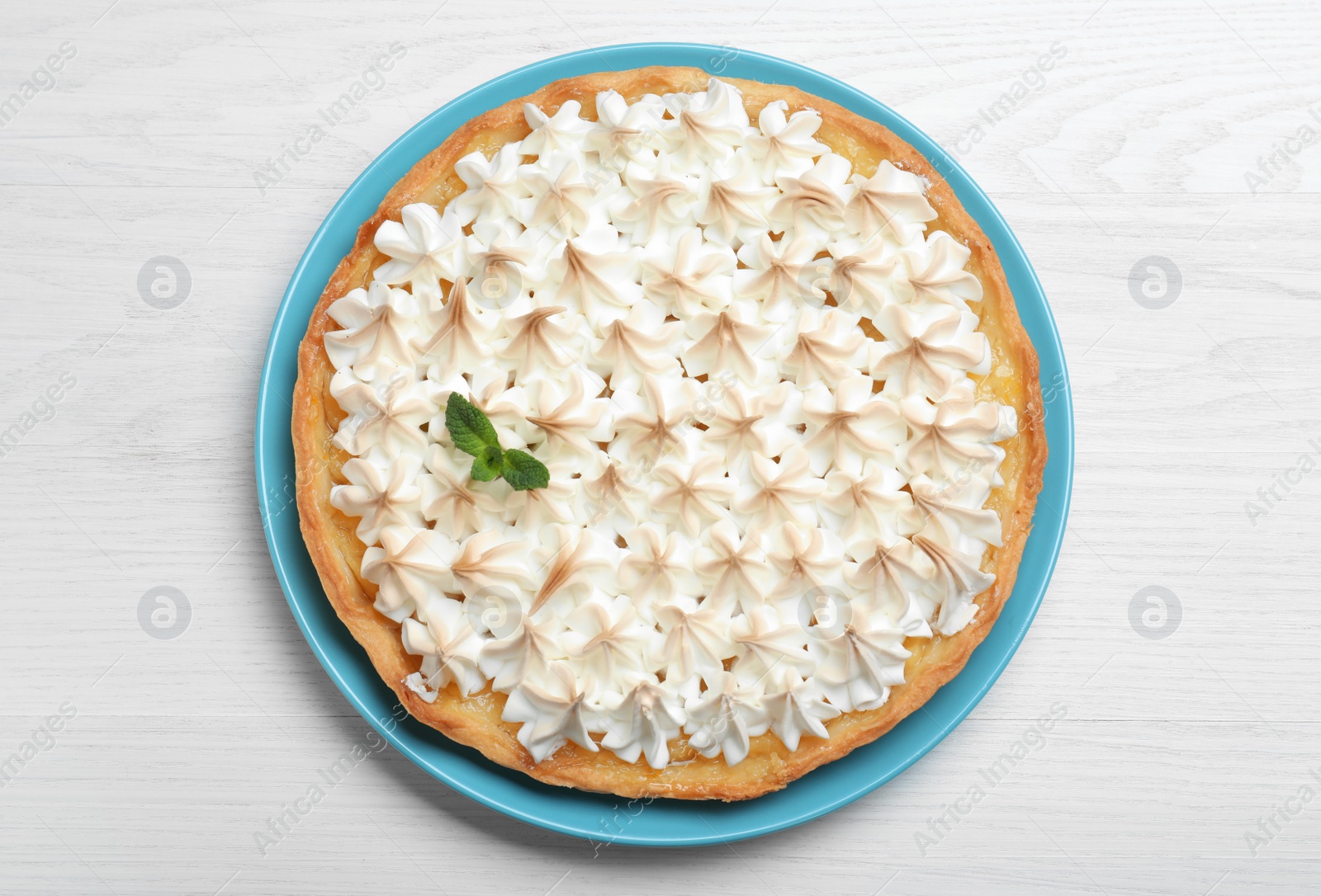Photo of Delicious lemon meringue pie decorated with mint on white wooden table, top view