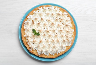 Delicious lemon meringue pie decorated with mint on white wooden table, top view