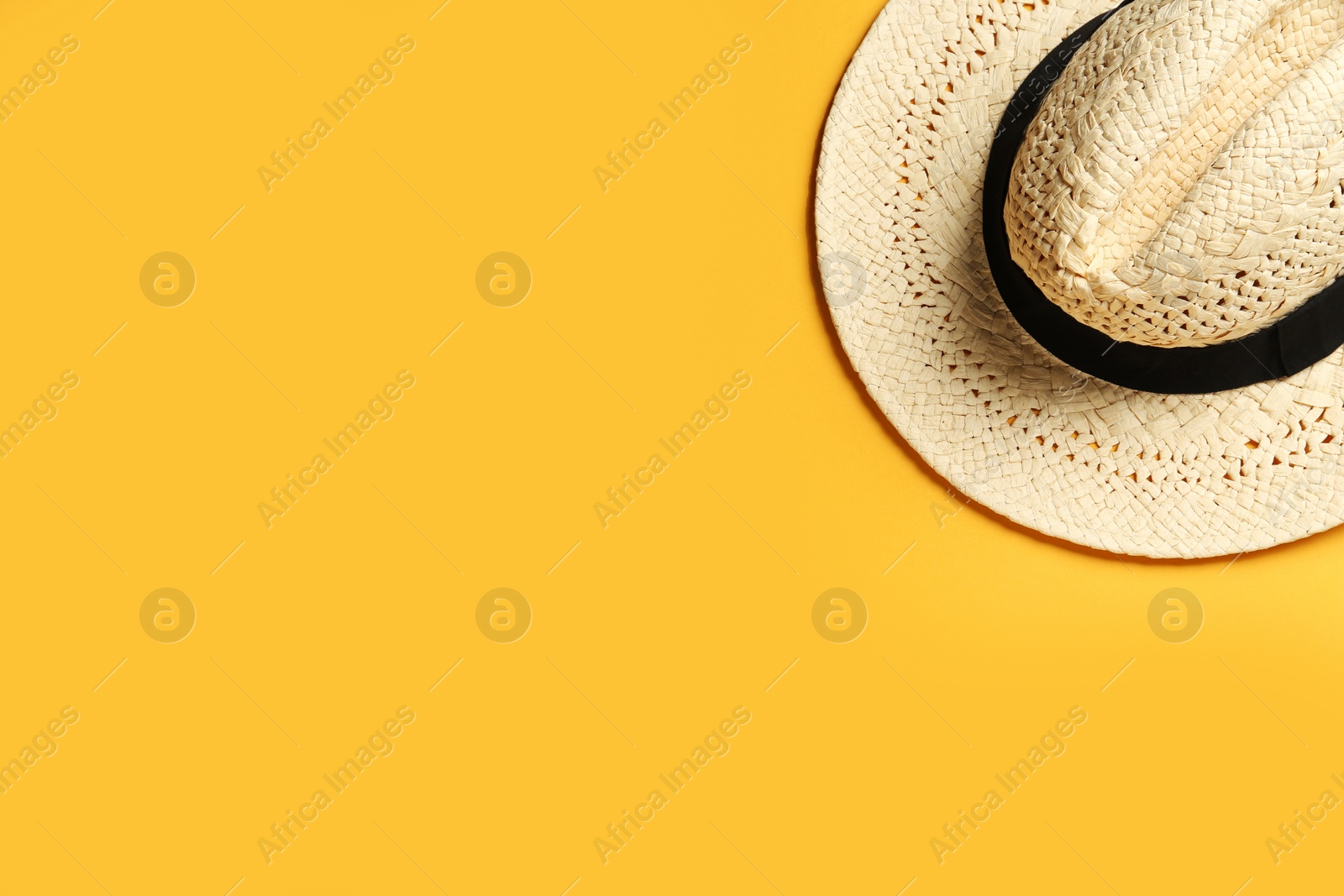 Photo of Hat on yellow background, top view with space for text. Sun protection accessory