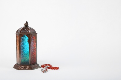Muslim lamp and prayer beads on white background. Space for text