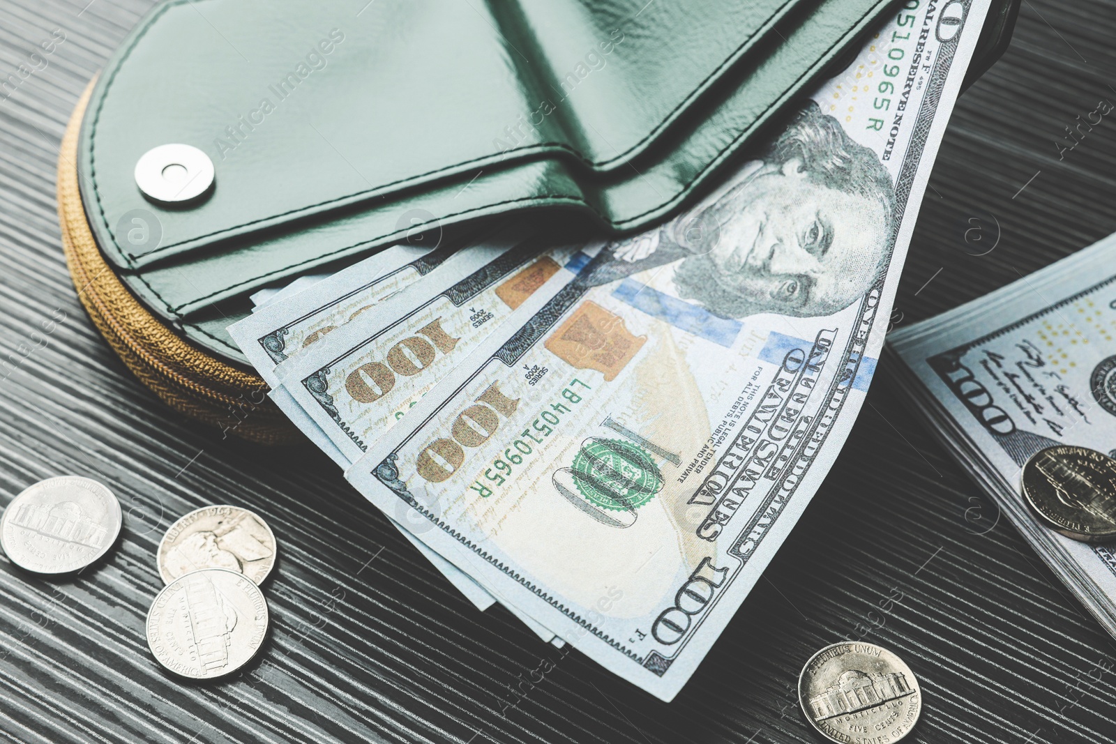 Photo of Dollar banknotes, coins and wallet on black wooden table, closeup. Money exchange