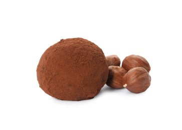Photo of Delicious chocolate truffle with cocoa powder and hazelnuts on white background