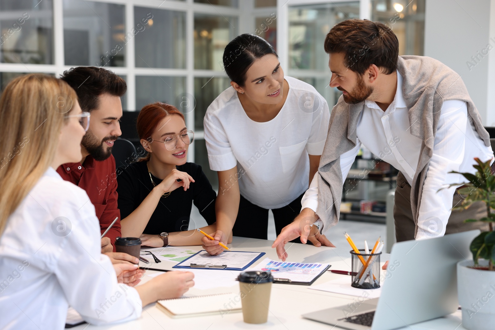 Photo of Team of employees working together in office