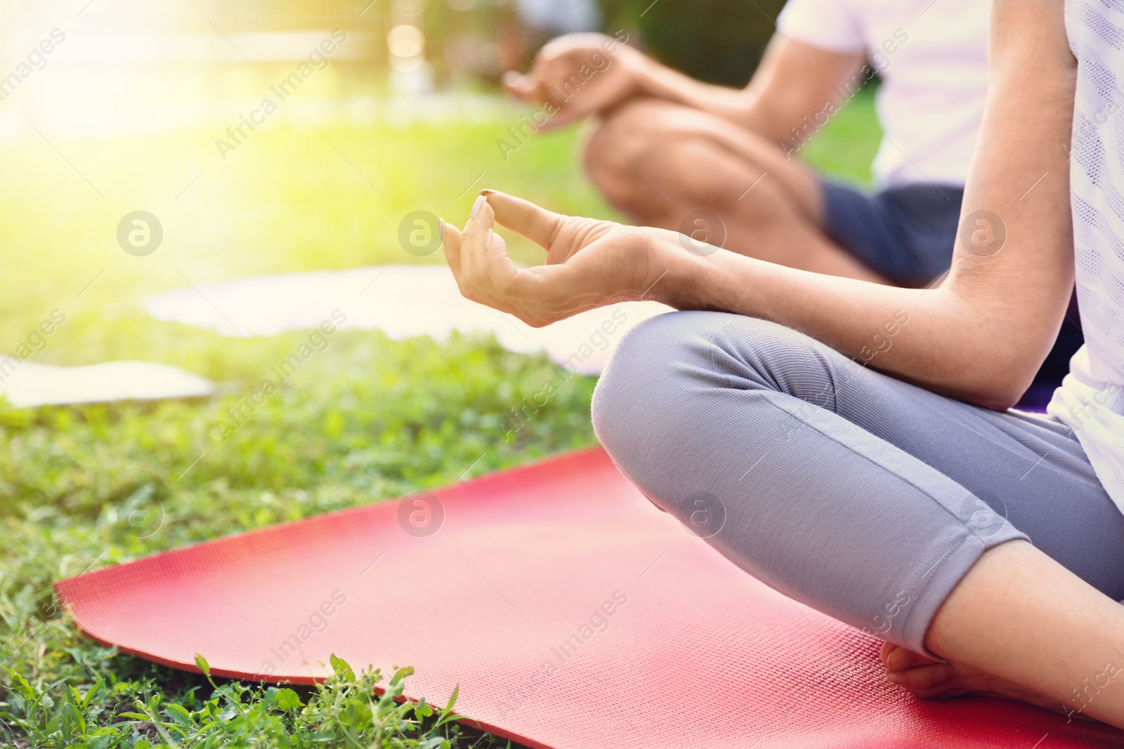 Image of Woman and man practicing yoga in park on sunny morning, closeup