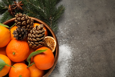 Flat lay Christmas composition with fresh tangerines and fir tree branches on grey background. Space for text