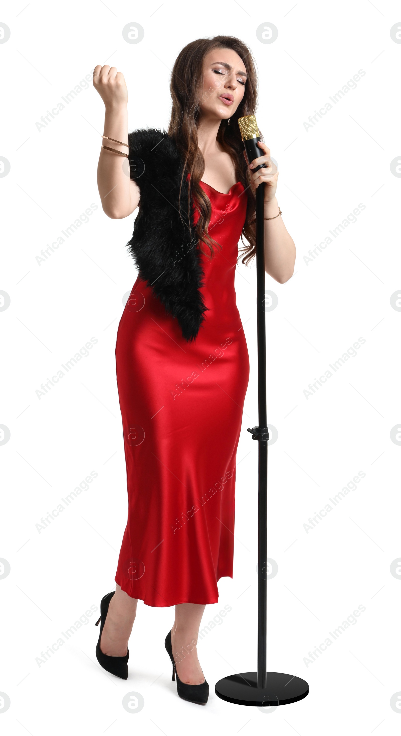 Photo of Beautiful young woman in stylish red dress with microphone singing on white background