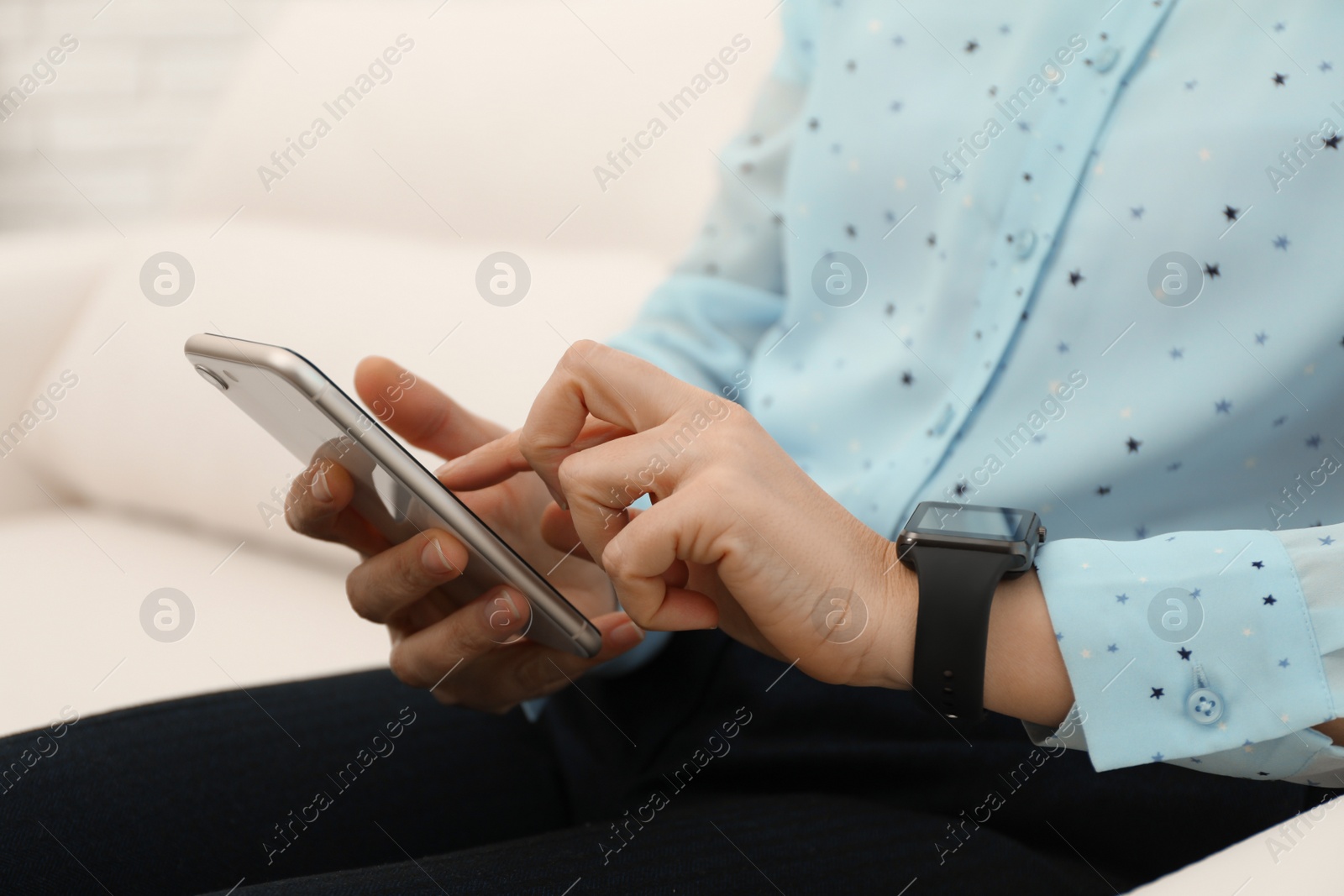 Photo of Mature woman with smart watch and phone indoors, closeup