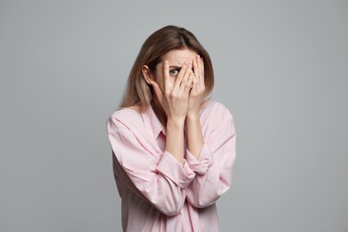 Photo of Young woman feeling fear on grey background