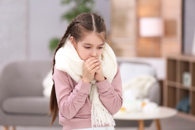 Photo of Sad little girl suffering from cold on blurred background