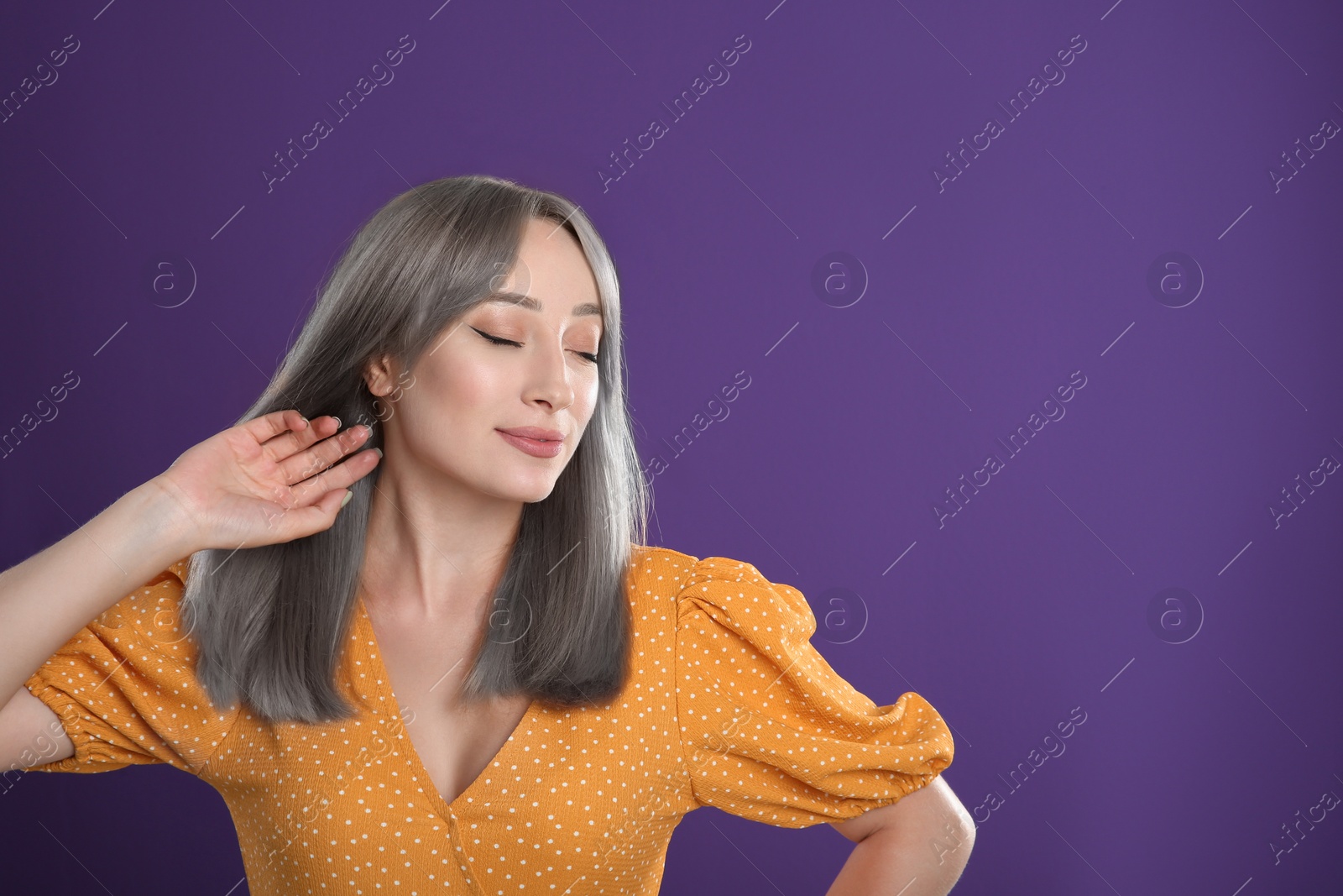 Image of Beautiful woman with ash hair color on purple background. Space for text