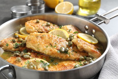 Delicious chicken piccata with herbs on table, closeup