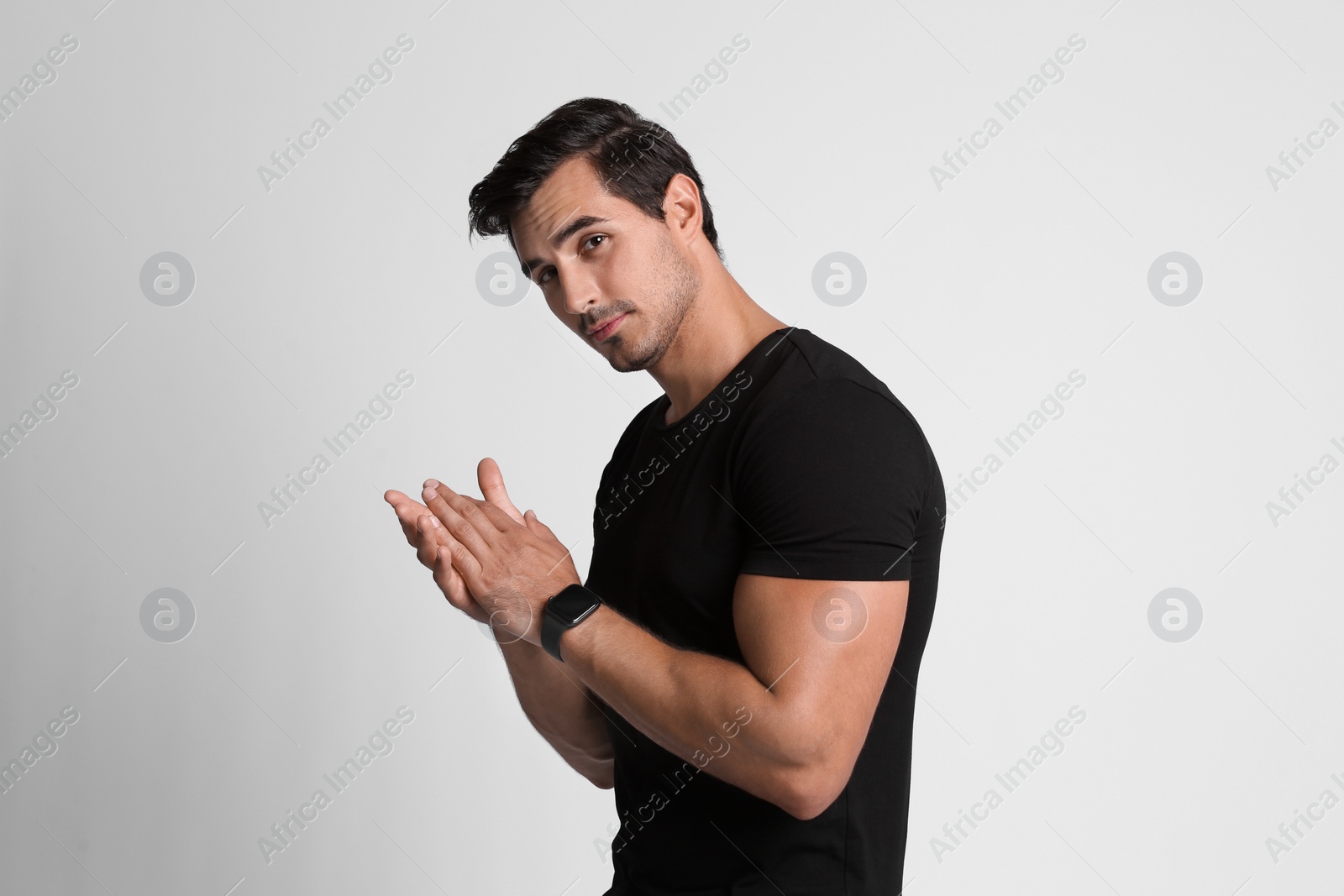 Photo of Portrait of handsome young man in black t-shirt on grey background