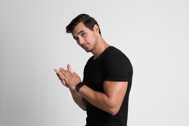 Photo of Portrait of handsome young man in black t-shirt on grey background