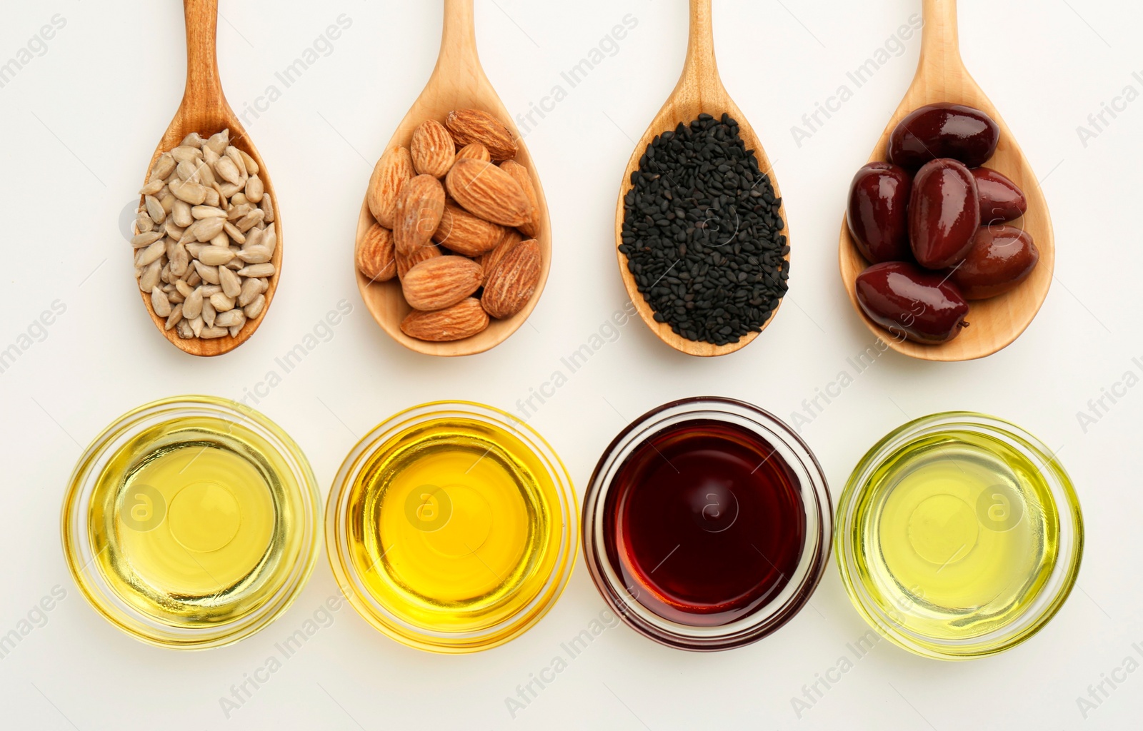 Photo of Vegetable fats. Different cooking oils in bowls and spoons with ingredients on white background, flat lay