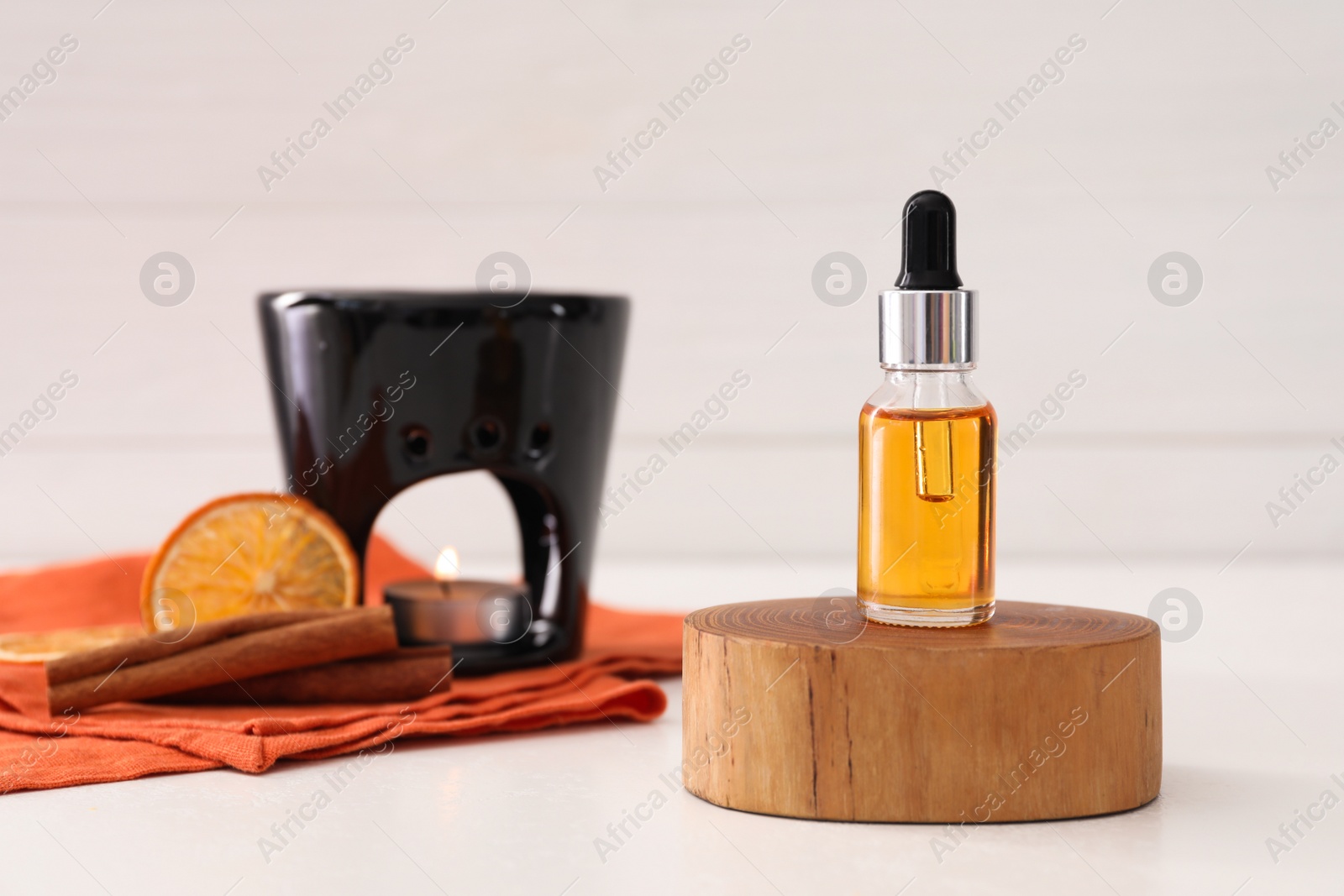 Photo of Aroma lamp and essential oil on white table, space for text