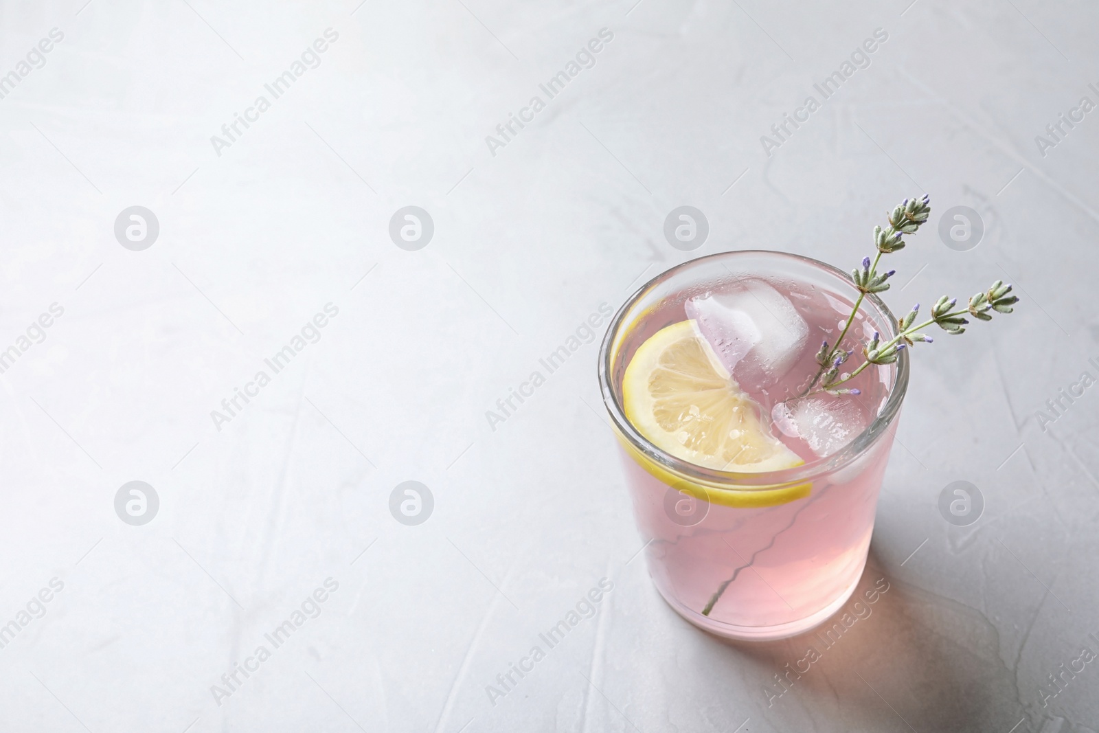 Photo of Natural lemonade with lavender in glass on light background